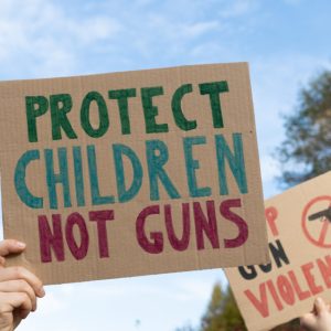 Protesters holding signs with slogans Protect Children Not Guns